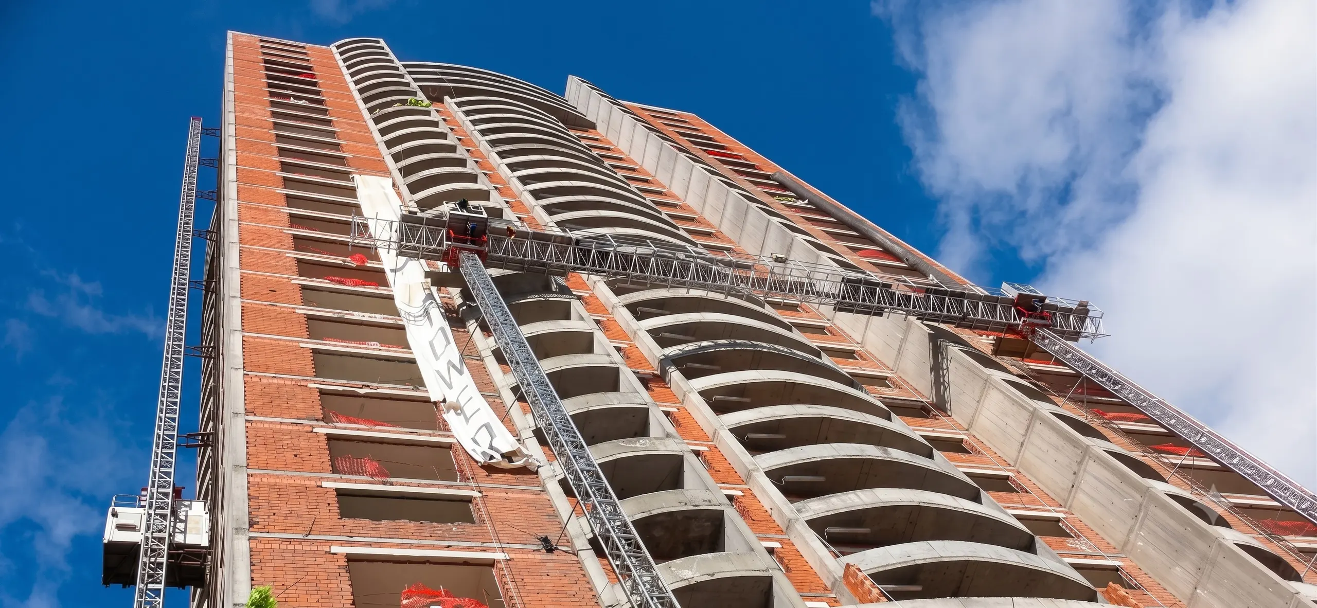 Encomat mast climbing work platform operating on a building facade